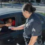 Police officer approaching man showing driver's license