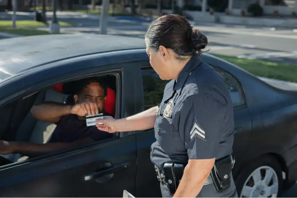 Police officer approaching man showing driver's license